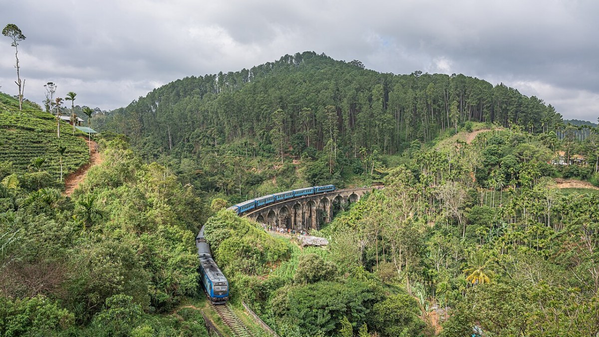Iconic blue train crossing the Nine Arch Bridge on the scenic Kandy to Ella railway route