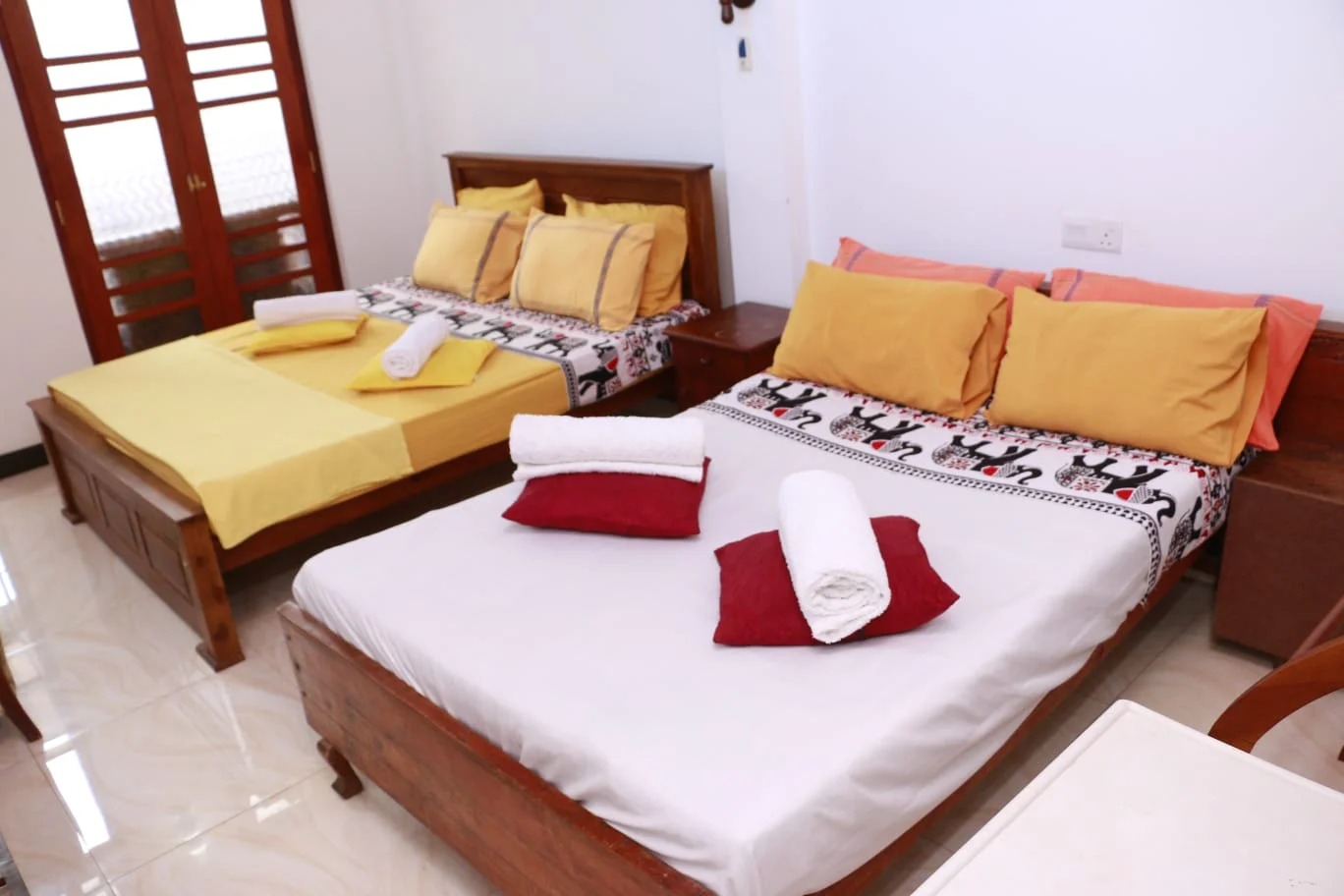 Deluxe Family Room — Spacious bedroom setup with queen bed, hardwood furnishings and bright natural lighting
